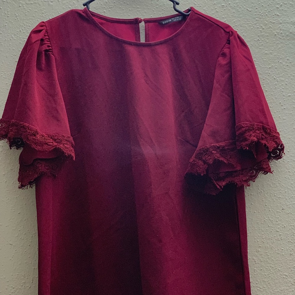 A beautiful burgundy top with embroidered sleeves